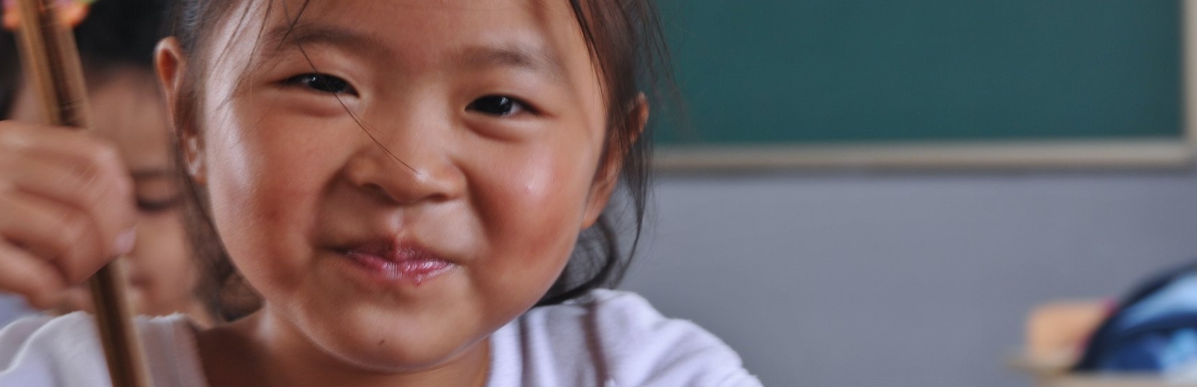 A schoolgirl in Shanghai, eats with her chopsticks during “Mr. Broccoli,” a Premiumaid Foundation program done in partnership with IKEA. Photo credit: Premiumaid Foundation, October 2011.