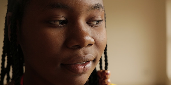 A girl starts at the camera. She has written a poem about her experience during the Coronavirus pandemic. 