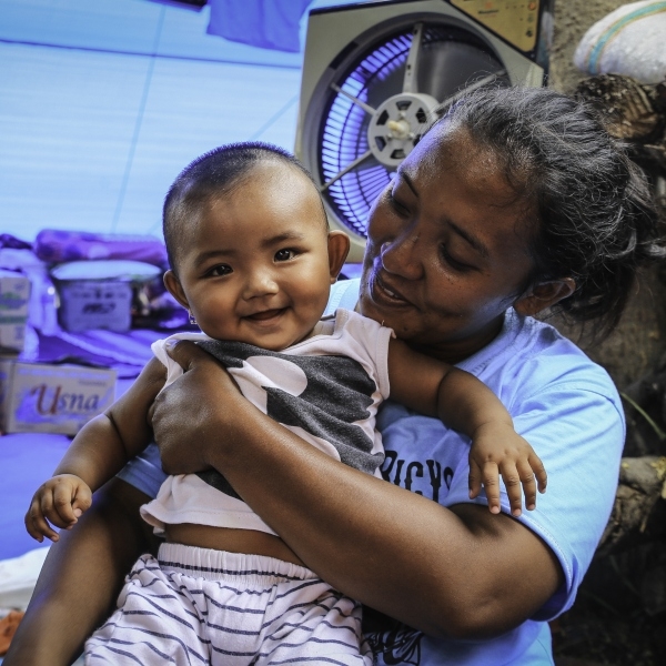 Mother and baby survive with their family in an evacuation camp in Indonesia after an earthquake.