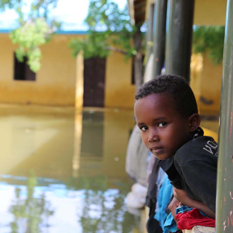 In Somalia, a boy looks out over a flooded river.