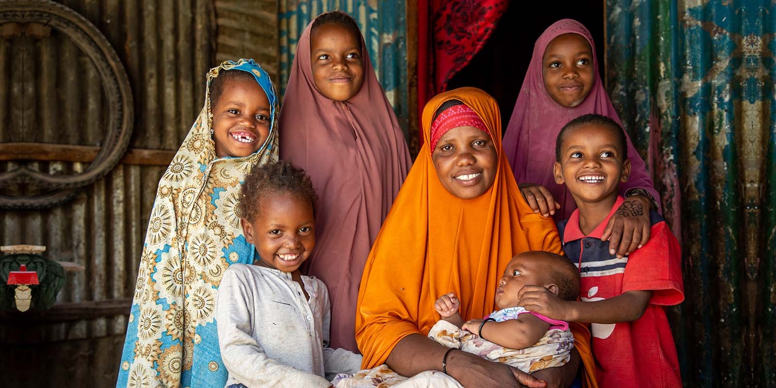 In Somalia, a family poses together while a mother holds a baby in her lap who has been treated for severe acute malnutrition.