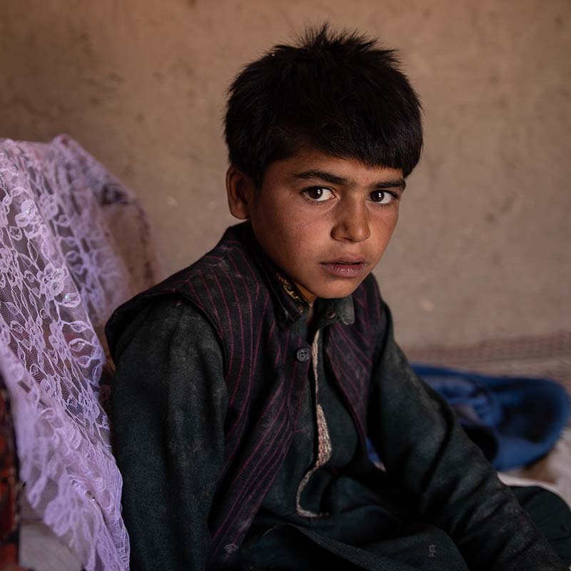 In Afghanistan, a boy sits alone in a room.