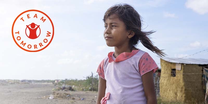In Cambodia, a young girl stands near the shoreline where debris has washed up. 