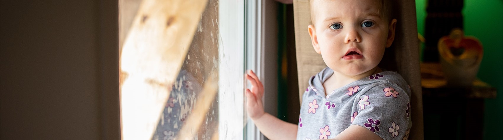 West Virginia, USA, a toddler in a gray floral shirt, looks at the camera